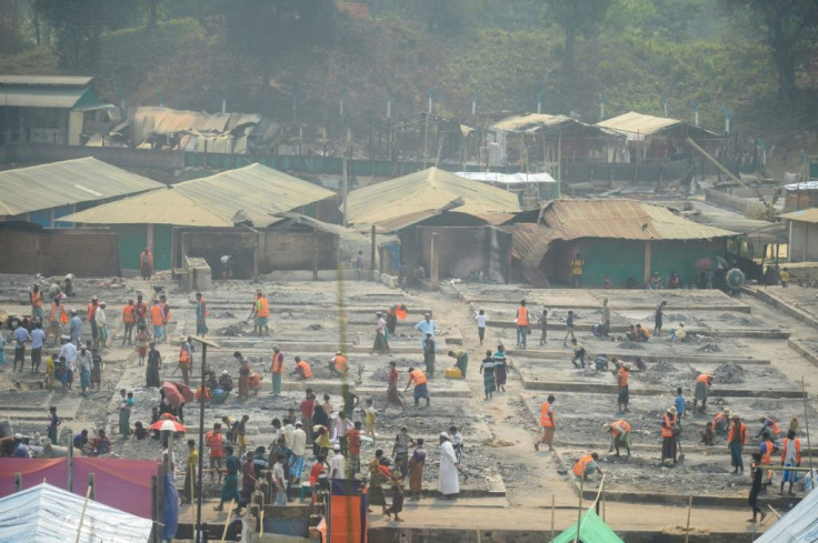 Rohingya refugees search for valuables in debris after a fire burnt their home at a refugee camp in Bangladesh