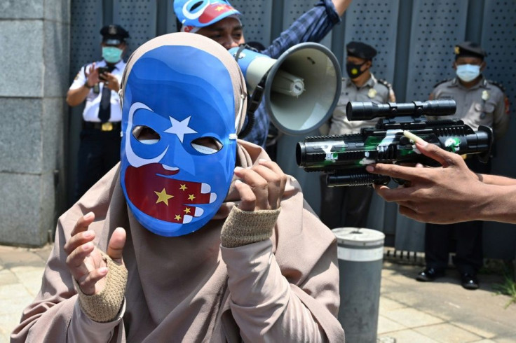 Indonesian student activists take part in a role-play as they demonstrate against alleged human rights abuses of China's Uyghur minority Muslim group, outside the Chinese embassy in Jakarta