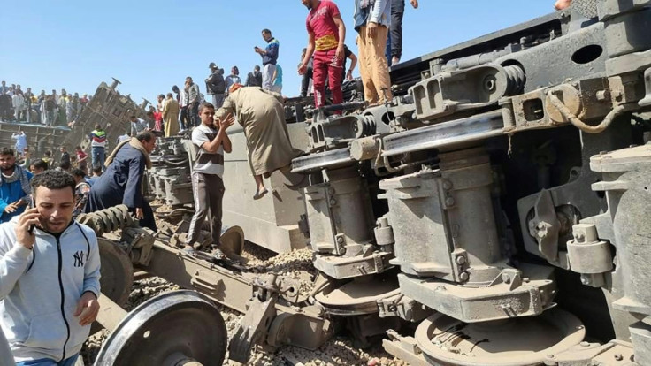 Rescuers gather around the overturned wreckage of two passenger trains that collided in the Tahta district of southern Egypt, killing at least 32 people