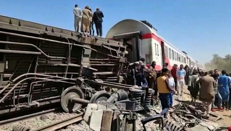 Axles, springs and twisted metal protrude from one of the railway carriages overturned in the collision in southern Egypt