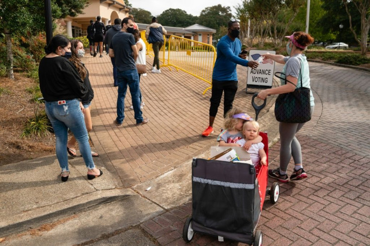 Now banned: Megan Dominy and her two children hand out bottles of water to people waiting in line to vote in the city of Smyrna, Georgia during the 2020 US election