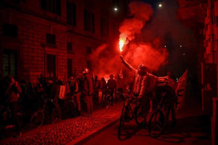 Food delivery men, one holding a smoke bomb, working for online food delivery platforms, protest in Milan amid coronavirus lockdown restrictions