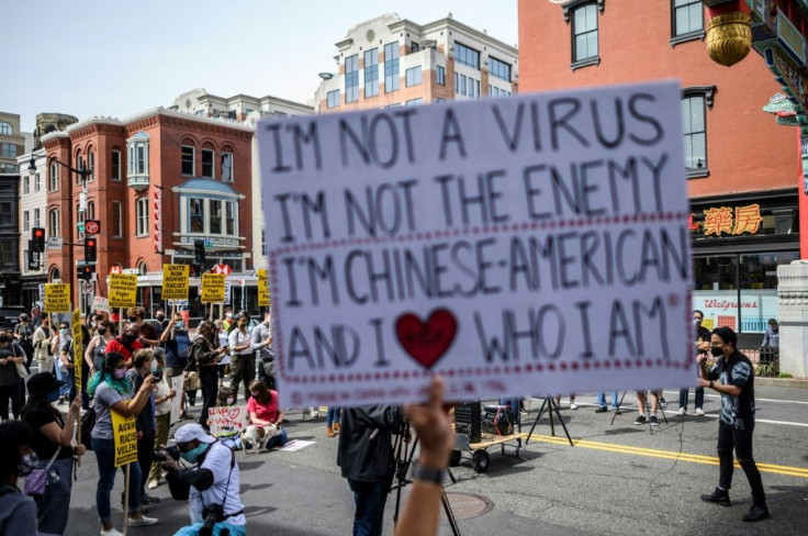 People listen to speakers as they participate in an 'Anti Asian Hate' rally in Chinatown in Washington, DC on March 27, 2021