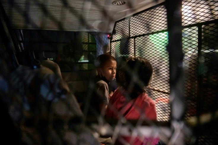 Two unaccompanied seven-year-old children wait in a Border Patrol van for processing after crossing the Rio Grande into Texas