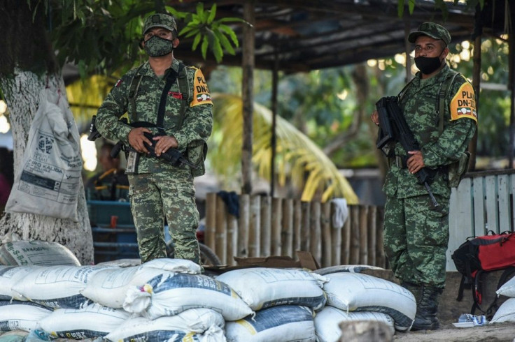 Mexican soldiers like these, seen standing guard on January 19, 2021 near the Suchiate River in Chiapas state, have been deployed in a joint border operation with Guatemala to stem the northward flow of migrants