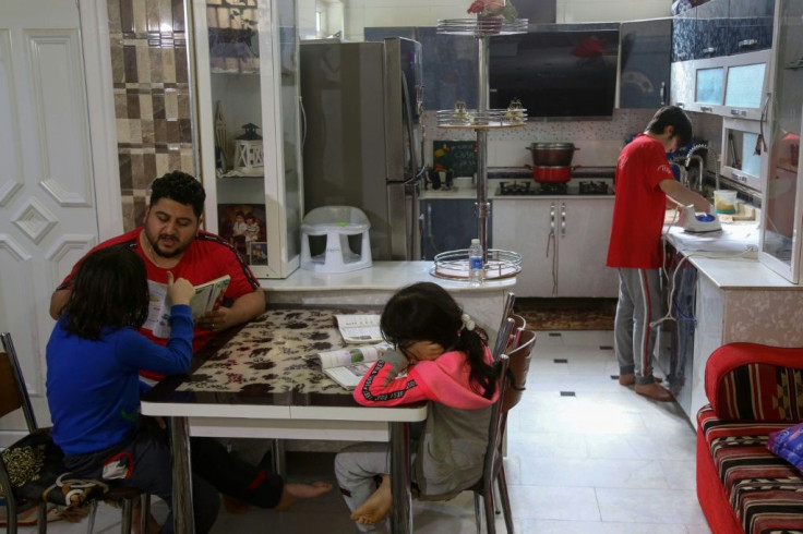 Iraqi engineer Hassanein Mohsen helps his children study at home in Karbala. Mohsen spent months protesting against corruption in Iraq