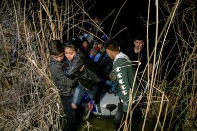 A group of undocumented migrants from Honduras and Guatemala get off a Mexican trafficker's boat on the US side of the border near Roma, Texas, on March 28 2021