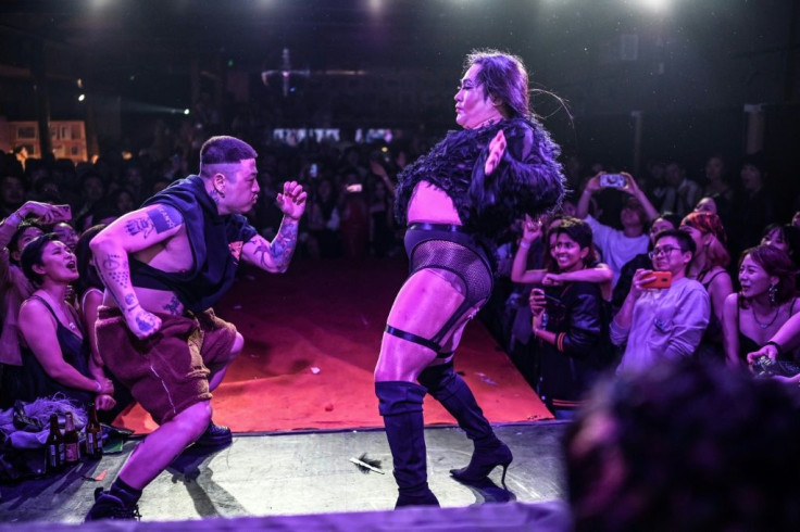 Two dancers competing on stage during a voguing ball at a bar in Beijing