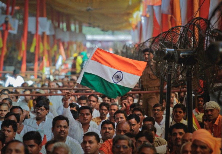 A man waves India&#039;s national flag during an address by yoga guru Ramdev to his supporters at Ramlila grounds in New Delhi