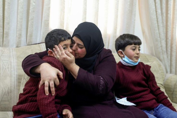 Dalal Zibn poses with her children Salaheddine and Muhannad, conceived via IVF, as their father is detained in Israel