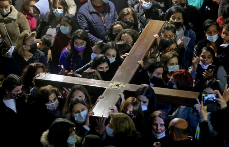 Christian worshippers carrying a wooden cross arrive at the Church of the Holy Sepulchre, during a Good Friday procession along the Via Dolorosa (Way of Suffering) in Jerusalem's Old City