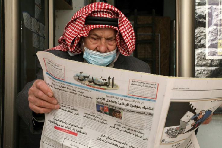 An elderly Palestinian man reads the daily newspaper Al-Quds, which published on its front page a story about the latest events in neighbouring Jordan
