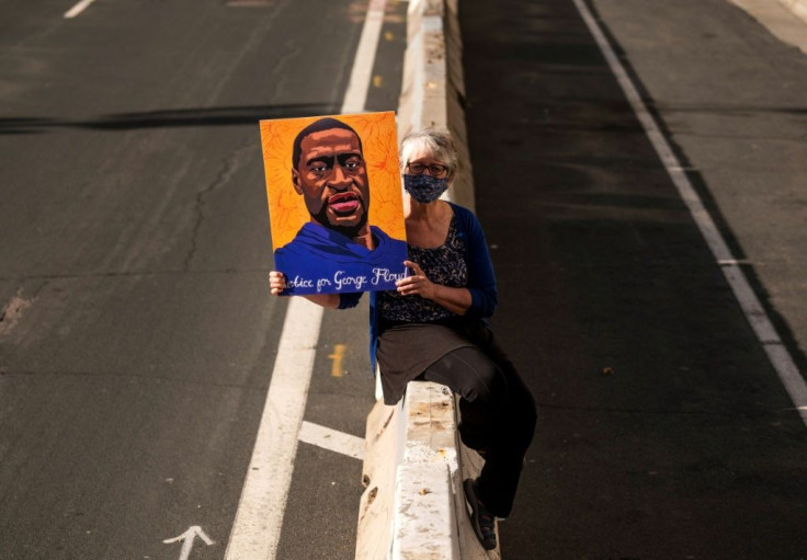 Margie O'Loughlin holds a portrait of George Floyd outside the Hennepin County Government Center where the trial of former police officer Derek Chauvin is taking place