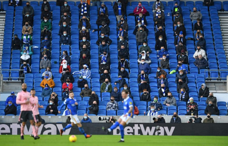 Fans wearing face masks sit socially distanced during an English Premier League football match