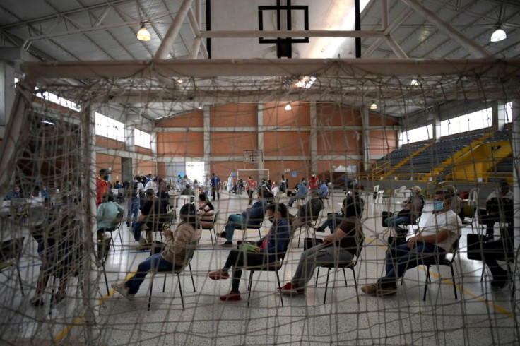 People wait to be inoculated with the AstraZeneca vaccine in Bogota. The city of eight million will be put under strict lockdown from Saturday to battle a third wave of the pandemic