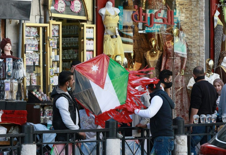 A shop in Amman where people handle a kite with a Jordanian national flag design