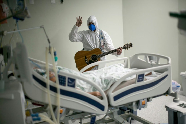 A hospital worker plays guitar for a Covid patient in Brazil, where confusion often reigns as the federal, state and local governments squabble over policy measures to contain the pandemic
