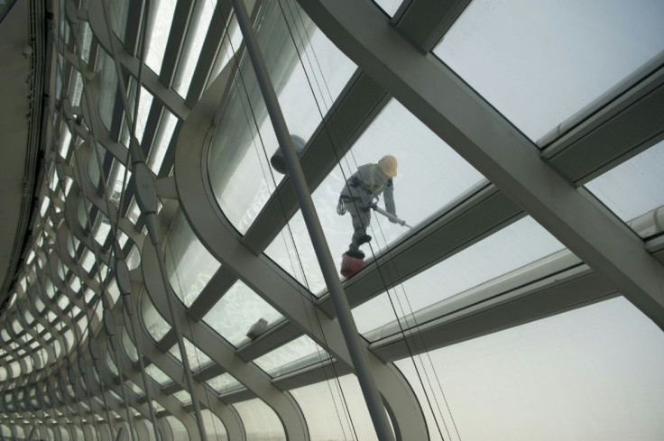 A worker cleans the roof of the National Speed Skating stadium at Beijing Olympic Park in March 2021 as preparations step up for the Winter Games