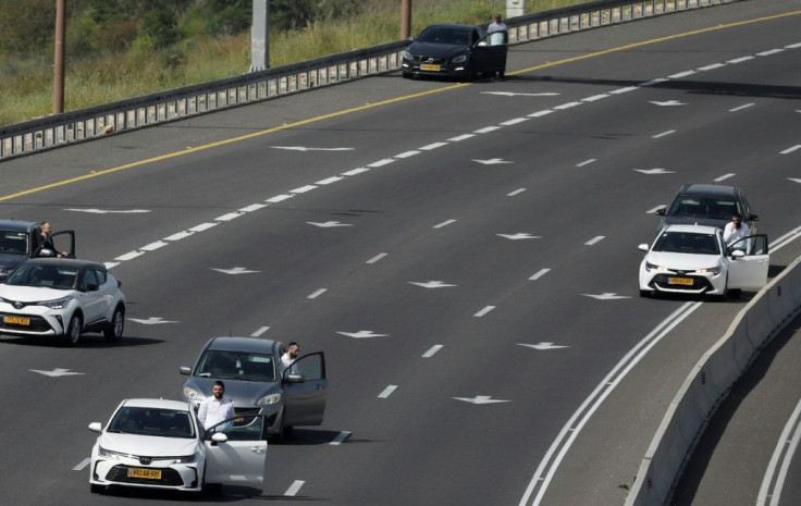 Israelis pause by their vehicles on the main highway leading to Jerusalem on April 8 as sirens wail across Israel for two minutes marking the annual day of remembrance for the six million Jewish victims of the Nazi genocide