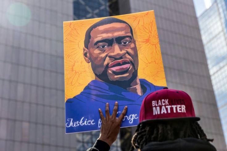 A demonstrator holds a sign with a picture of George Floyd during a protest outside the Hennepin County Government Center in Minneapolis, Minnesota, where former police officer Derek Chauvin is on trial