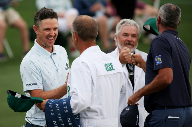 England's Justin Rose, left, bumps fists with caddie David Clark after firing a seven-under par 65 in Thursday's opening round of the Masters