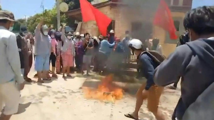 Protesters in Myanmarâs southern Launglone township burn copies of the 2008 constitution and printed papers of the Chinese and Russian flags, demonstrating their opposition to the two nationsâ close relations with the military junta.