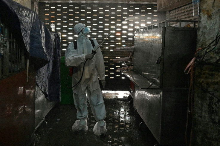 A worker sprays disinfectant at Orussey Market in the Cambodian capital Phnom Penh