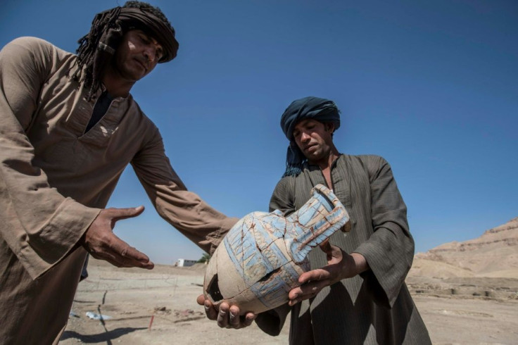 At the site near Luxor, home of the legendary Valley of the Kings, workers carefully carried ancient pots and showed human and animal remains dug up from the earth as members of the media toured around curved brick walls and rudimentary streets