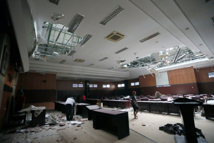 Workers clear debris from the hall of a local parliament building in Blitar, after a 6.0 magnitude earthquake struck off the coast of Java island