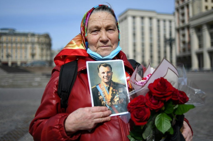 A Russian Communist party supporter holds a Gagarin portrait before attending a flower laying ceremony at the late cosmonaut's grave in Moscow