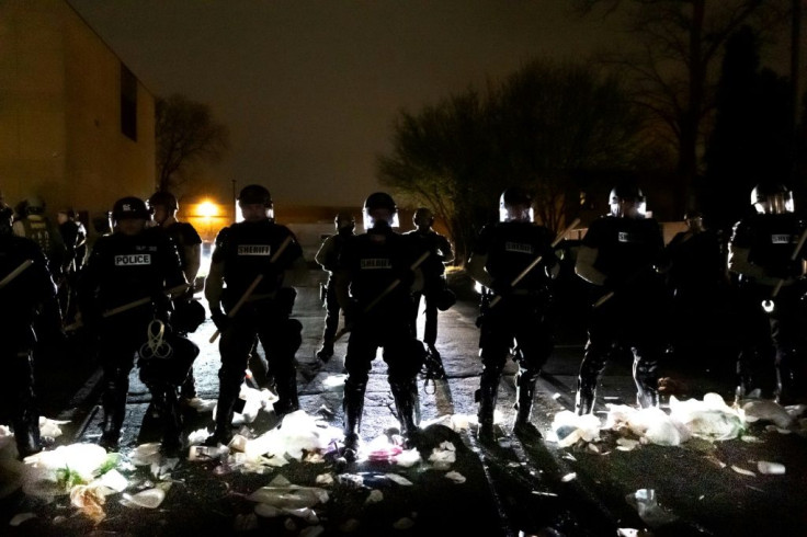 Police officers stand outside the Brooklyn Center police station during protests over the shooting of a Black man in the Minneapolis suburb