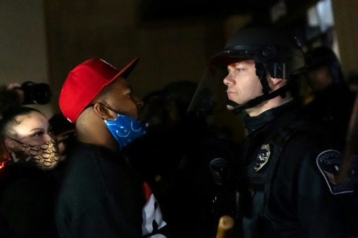 Protesters face off with police officers in front of the Brooklyn Center police station