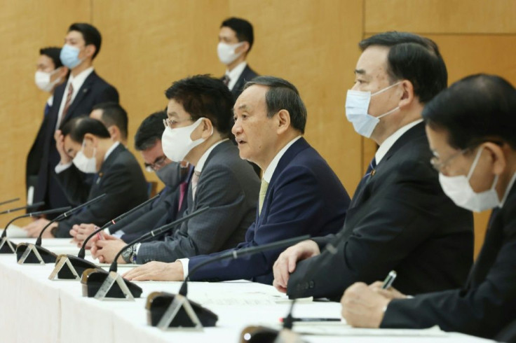 Japan's Prime Minister Yoshihide Suga (C) told a ministerial meeting that disposing of the water was an 'inevitable task'