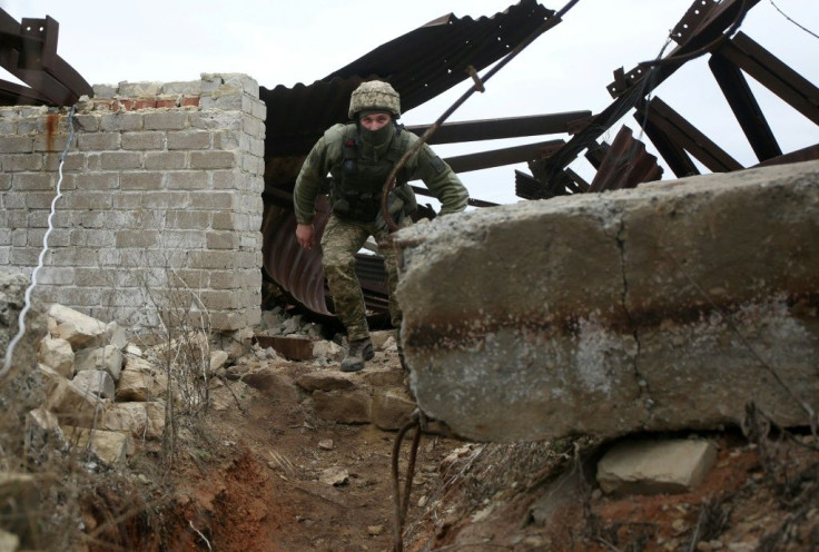 A Ukrainian serviceman patrols at a position on the frontline