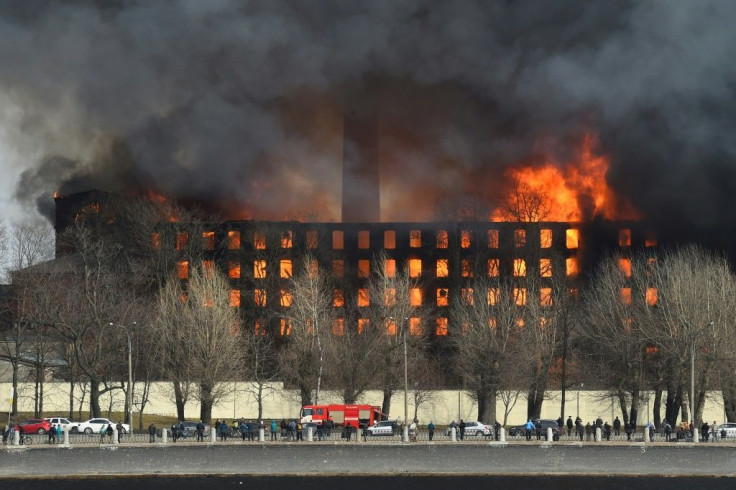 Firefighters work to extinguish the blaze at the historic factory in Saint Petersburg on Monday