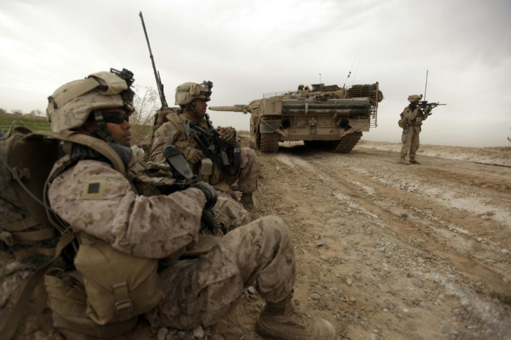 US Marines patrol past a Danish army tank as they clear explosives in the northeastern outskirts of Marjah in February 2010