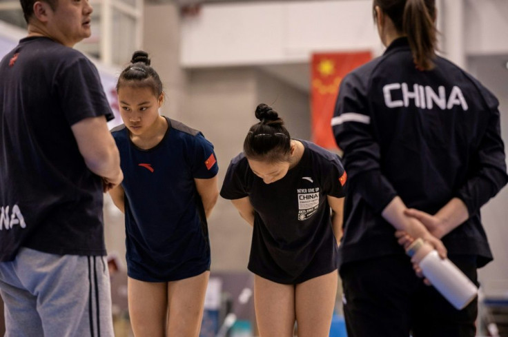 Gymnasts Cheng Shiyi (2nd L) and Yu Linmin (2nd R) bow after being told to improve their technique and motivation during a session at the National Training Centre in Beijing