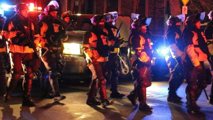 Riot police fire tear gas and rubber bullets at demonstrators who protest for a fourth night outside the Brooklyn Center police department in Minnesota following the April 11th police killing of Daunte Wright, a 20-year-old Black man.