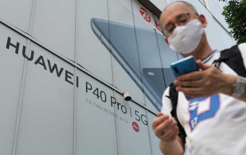 A pedestrian in Tokyo walks in 2020 under an advertisement for Chinese telecoms company Huawei, whose strength in 5G internet has alarmed the United States