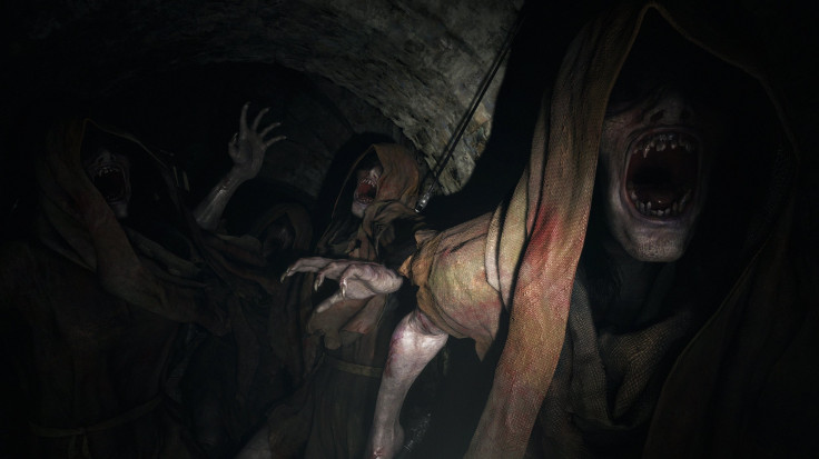 Hooded thralls lurk inside the dark tunnels of the castle in Resident Evil Village