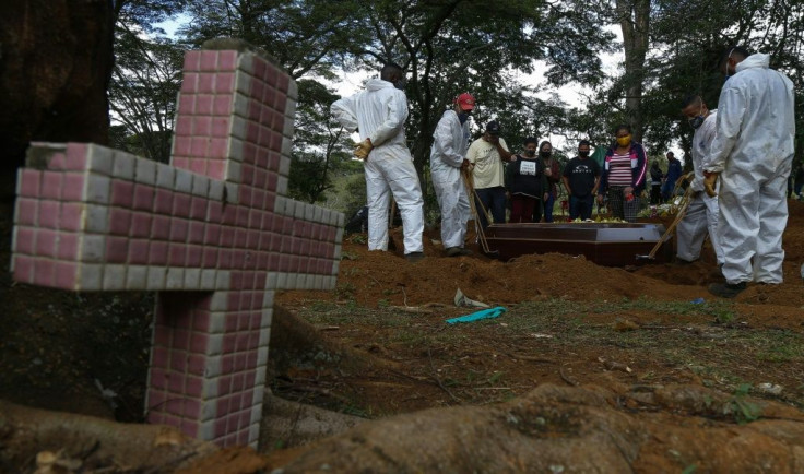A coffin being buried at the Vila Formosa cemetery in Sao Paulo, Brazil, on April 14, 2021, as a second wave of the coronavirus pandemic forces the city to allow burials at night