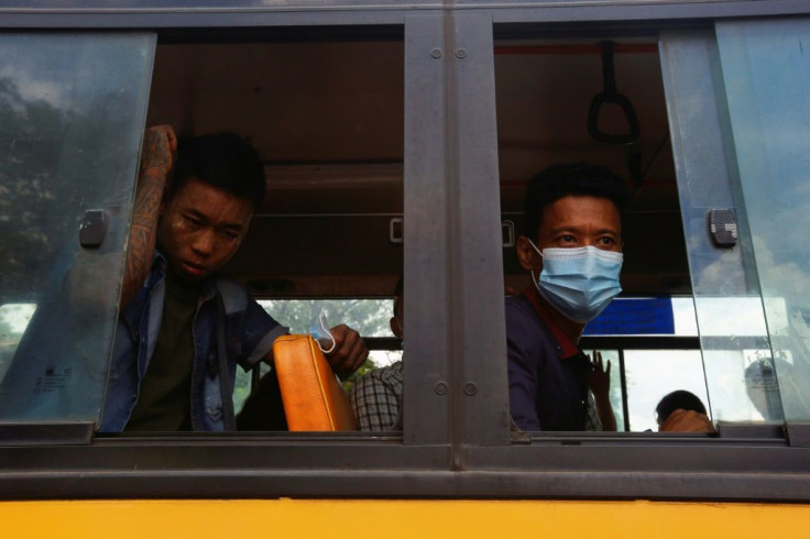 Newly released prisoners look on from a bus outside Insein Prison in Yangon