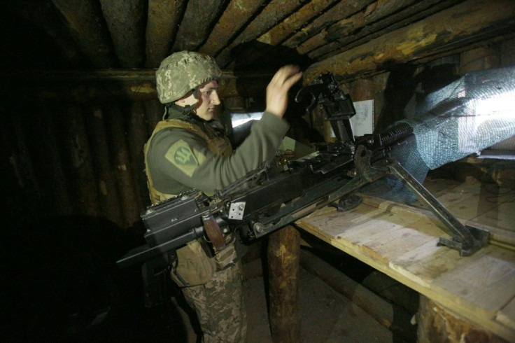 A Ukrainian soldier loads a heavy machine gun at a position on the frontline