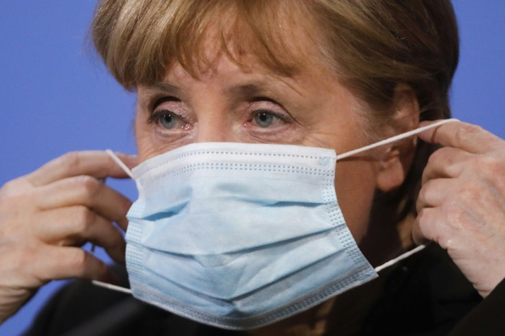 German Chancellor Angela Merkel puts on her face mask after addressing a press conference on March 30