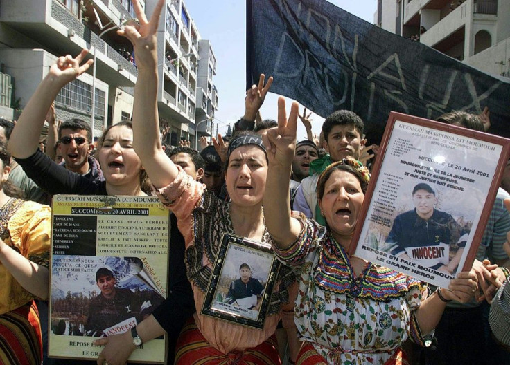 The mother (R) and sister (2nd R) of Massinissa Guermah hold pictures of him during a demonstration in April 2002, a year after he was killed by police