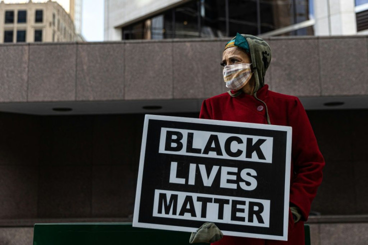 A woman holds a sign outside the Hennepin County Government Center where Derek Chauvin is on trial