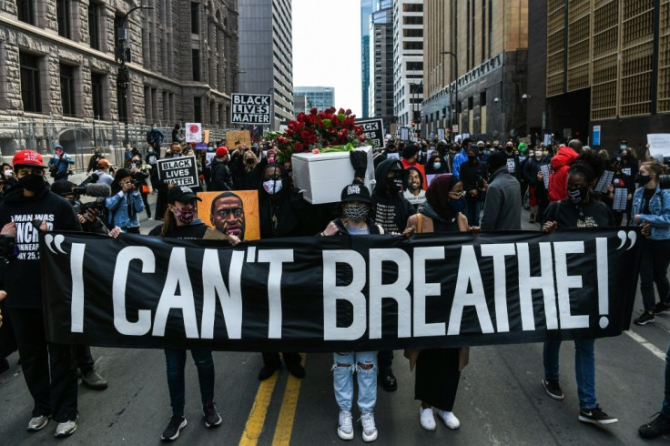 Demonstrators carry a banner reading "I Can't Breathe" during a March 7, 2021 march in Minneapolis
