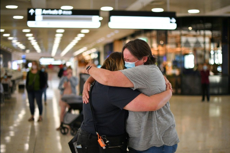 A mother (R) embraces her daughter upon her arrival from New Zealand at Sydney International Airport