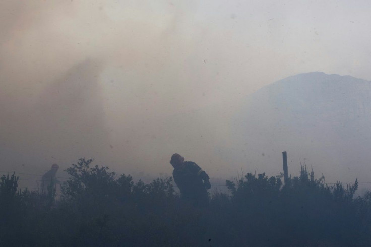 Firefighting teams work to keep the blaze from crossing Philip Kgosana Drive, one of the main arterial roads into Cape Town's city centre