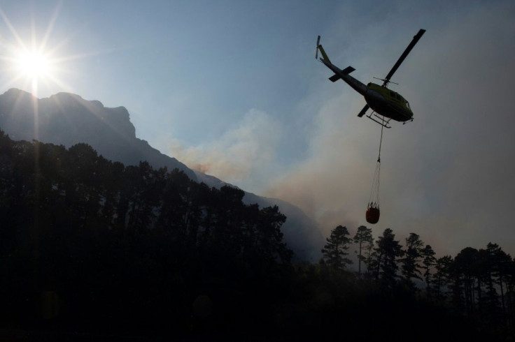 A firefighting helicopter picks up water from a reservoir